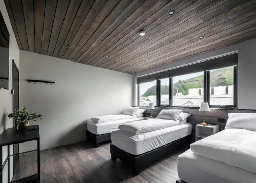 1 dormitorio con 2 camas y techo de madera en Pier Apartments, en Vestmannaeyjar