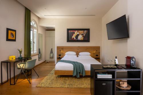 a bedroom with a large bed and a desk at Schumacher Hotel Haifa in Haifa