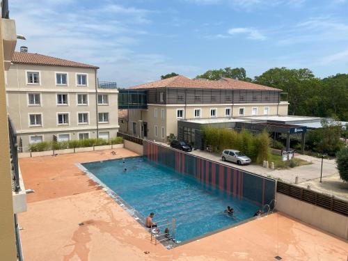 vista sul soffitto di una piscina di fronte a un edificio di Studio Residence Cote Green a Montpellier