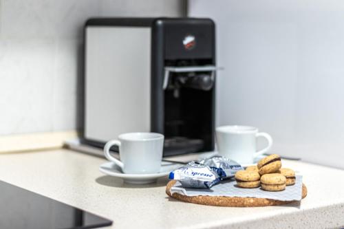 a counter with two coffee cups and a plate of cookies at Quick Home Agatha Apt in Santhià