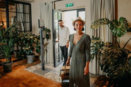 a woman in a dress holding a suitcase at Orbeliani Residence Hotel in Tbilisi City