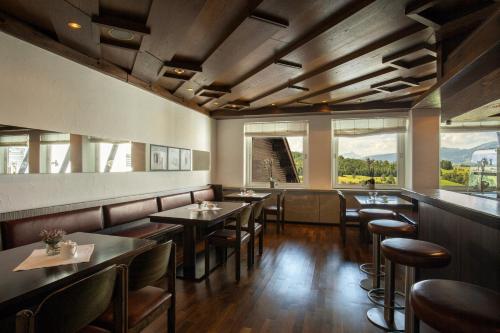 a restaurant with tables and chairs and large windows at AllgäuStern Hotel in Sonthofen