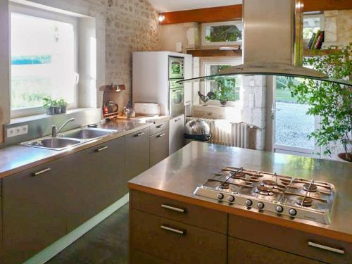 Il comprend une cuisine équipée d'une cuisinière et d'un évier. dans l'établissement Maison spacieuse avec piscine au cœur de Bellon, à Bellon