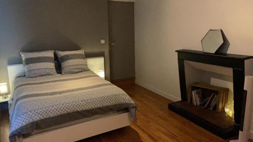 a bedroom with a bed and a fireplace at Place au Repos in Mouilleron-en-Pareds