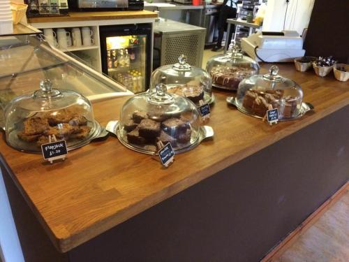 a counter with four glass domes filled with pastries at South Downs Eco Lodge & Camping in East Meon