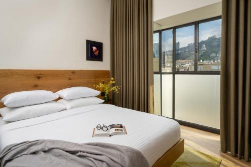 a bedroom with a bed and a large window at Schumacher Hotel Haifa in Haifa