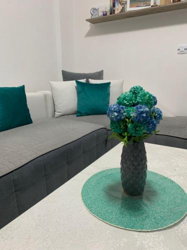 a vase with blue flowers in a living room at Mavrovo Twins Apartment in Mavrovo