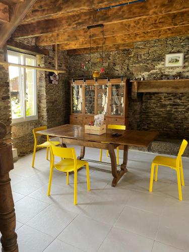 une salle à manger avec une table en bois et des chaises jaunes dans l'établissement Les Chambres De Napoleon, à Lannédern
