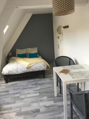 a bedroom with a bed and a table with chairs at LA MANSARDE - AU CŒUR DE LA VIEILLE VILLE in Boulogne-sur-Mer