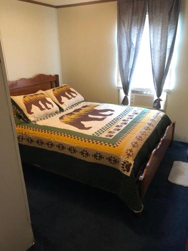 a bedroom with a bed with a blanket on it at Smokey Mountain Overlook in Bryson City
