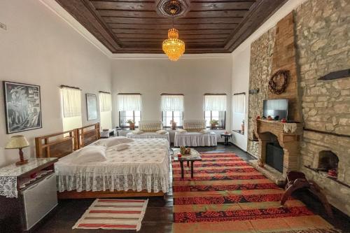 a bedroom with two beds and a fireplace at Bujtina Kodiket Guesthouse in Berat
