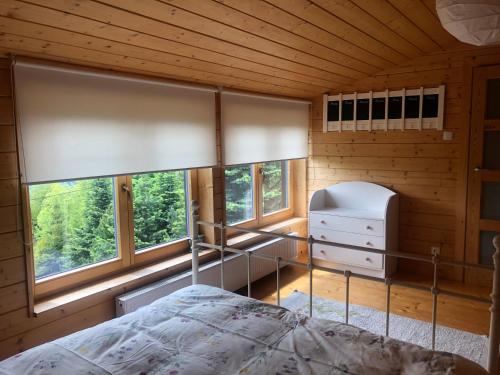 een slaapkamer met een bed en 2 ramen bij Przystanek Klimczok in Szczyrk
