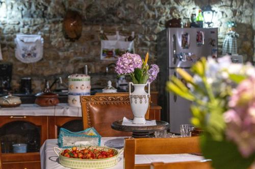 a kitchen with a table with a vase of flowers at Bujtina Kodiket Guesthouse in Berat