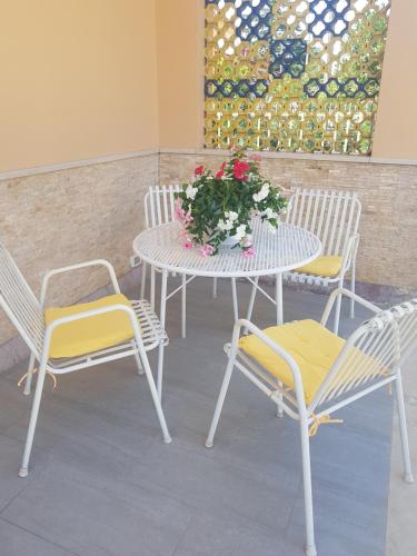 a table with two chairs and a table with flowers on it at B&B La pineta in Quasani