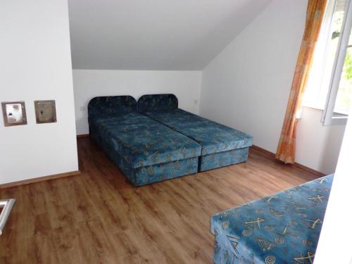 a bedroom with a bed and a blue ottoman at Traumblick Appartement am Balaton in Fonyód