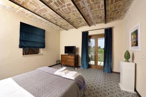 - une chambre avec un lit et une télévision à écran plat dans l'établissement La Cascina di Chiara, à San Martino sulla Marruccina