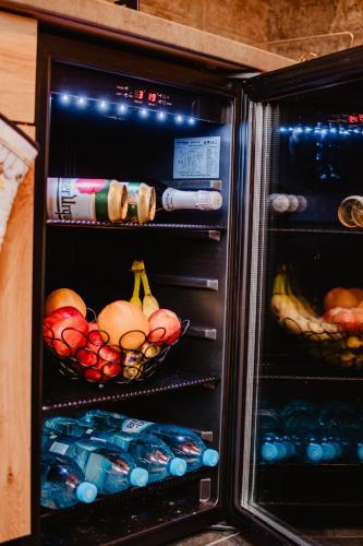 a refrigerator with two baskets of fruit and drinks at Chalupa Lieskovec in Tatranska Strba