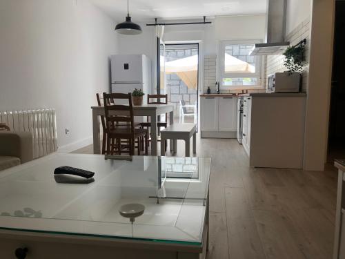 cocina y sala de estar con mesa y sillas en Casa Navalhorno- barrio nuevo Valsain, en Segovia