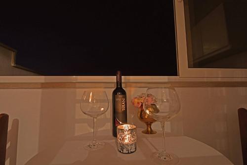 a bottle of wine and two glasses on a table at ꕥ ROOMS SUNCE, Family choice, Best Panoramic view, Supetar Island Brac in Supetar
