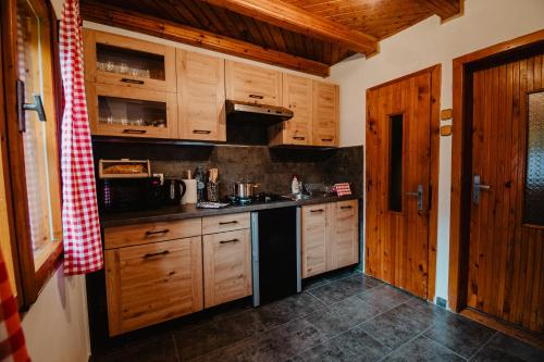 a kitchen with wooden cabinets and a counter top at Chalupa Lieskovec in Tatranska Strba