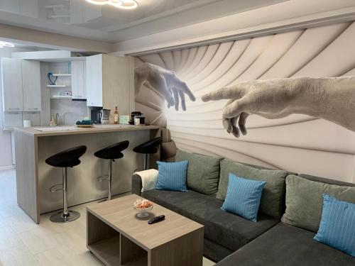 a living room with a couch and a painting of two hands at Apartament delmar (Ștefan building resort) in Mamaia Nord