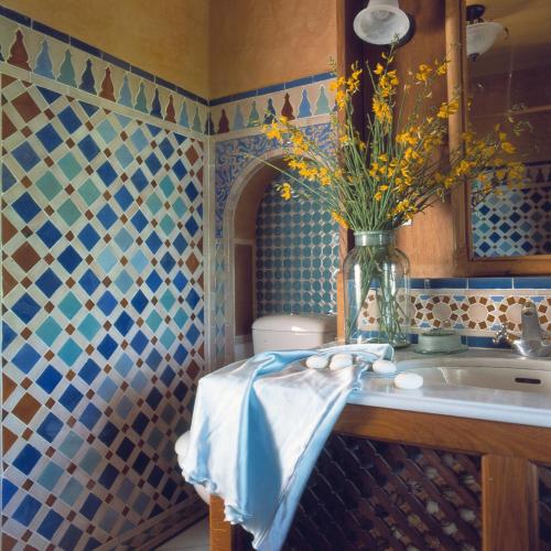 a bathroom with a sink and a vase of flowers at Cortijo Prado Toro in Pitres