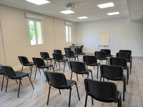 an empty room with chairs and a white wall at B&B HOTEL Agen Castelculier in Castelculier