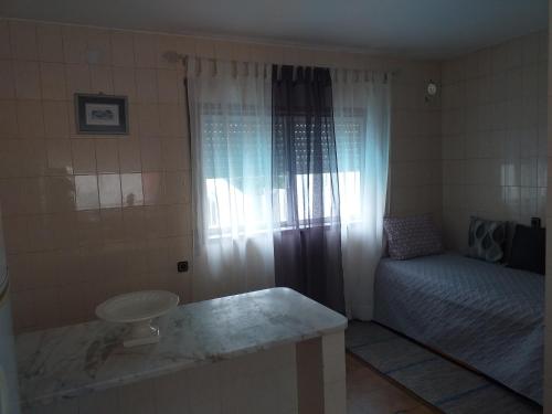 a room with a bed, a toilet and a window at Enjoy Guest House GMR in Guimarães