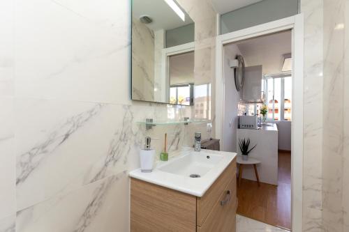 een badkamer met een wastafel en een spiegel bij Yumbo Teror Two Bedroom Apartment in Playa del Inglés