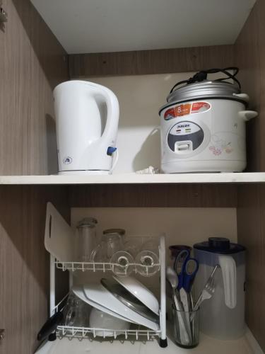 a kitchen shelf with a tea pot and a toaster at Mack's Awesome Place 24 with Netflix and FastUnliwifi in Manila