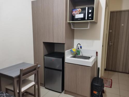 a small kitchen with a sink and a microwave at Mack's Awesome Place 24 with Netflix and FastUnliwifi in Manila