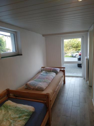 1 dormitorio con 2 camas y ventana en Ferienwohnung Angelburg - Marburg Biedenkopf mit Terrasse, en Gönnern