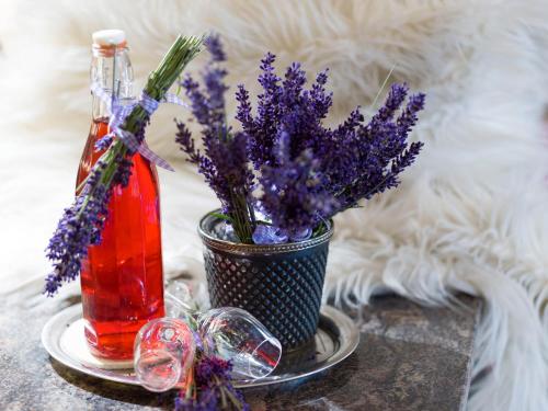 a vase of purple flowers and a bottle of liquid at Hotel Landhaus Zillertal in Fügen
