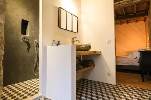 une salle de bain avec un lavabo et une chambre avec un lit dans l'établissement La Maison D'Aimé, à Saint-Quentin-la-Poterie