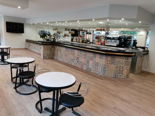 a restaurant with tables and chairs and a bar at HOTEL PARQUE PORRIÑO in Porriño