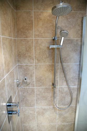a shower with a shower head in a bathroom at Field Cottage Bed and Breakfast in East Harling
