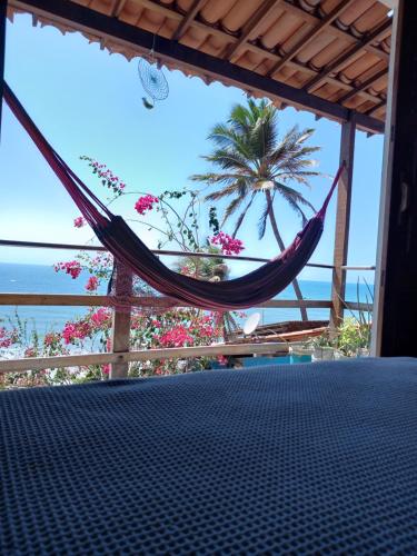 a hammock on a porch with a view of the ocean at Aloha in Icapuí