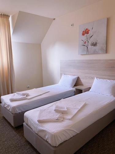 two beds in a hotel room with white sheets at SameТой in Mukacheve