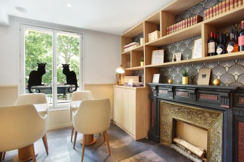 un salon avec une cheminée et une fenêtre dans l'établissement Hotel Le Chat Noir, à Paris