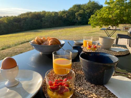 a table with a breakfast of fruit and orange juice at Domaine de Cazal - Chambres d'Hôtes avec piscine au cœur de 26 hectares de nature préservée in Saint-Cyprien