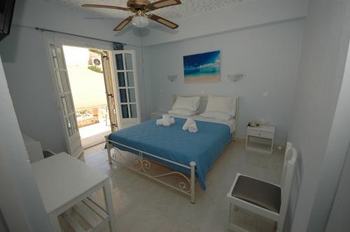 een slaapkamer met een bed en een plafondventilator bij Pension Ocean View in Naxos Chora