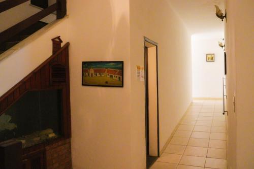 a hallway with a painting of a building on the wall at Hotel Itamaracá in Miguel Pereira