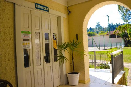a door to a school with a potted plant at Hotel Itamaracá in Miguel Pereira
