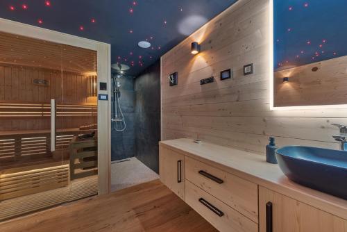 a bathroom with a blue sink and a sauna at Log House The River Pearl in Brod na Kupi