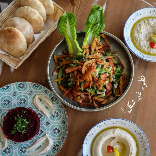 a table with a bowl of food and plates of food at Crystal Suites in Amman
