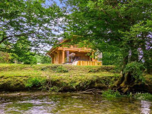 a log cabin on a hill next to a river at Log House The River Pearl in Brod na Kupi