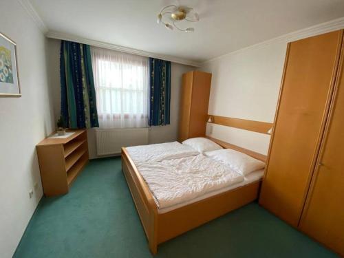 a small bedroom with a bed and a window at Ferienwohnung Schnaitl in Maria Alm am Steinernen Meer