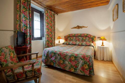 a bedroom with a bed and a chair at Hostal Casa Blasquico - Restaurante Gaby in Hecho