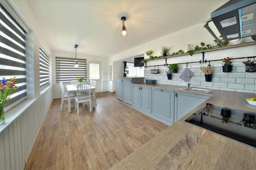 a kitchen with blue cabinets and a table and chairs at Chata Malá Skála v Českém ráji in Malá Skála
