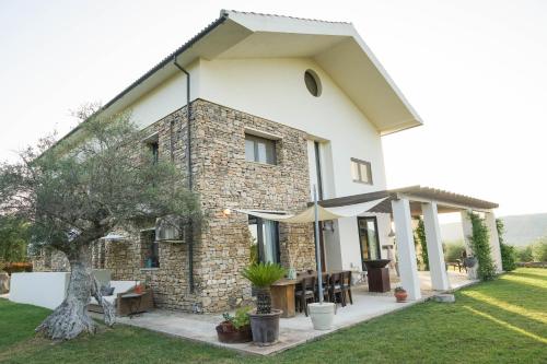 una casa in pietra con patio esterno con ombrellone di El Toro Blanco Luxury Villa in Andalucia a Ronda